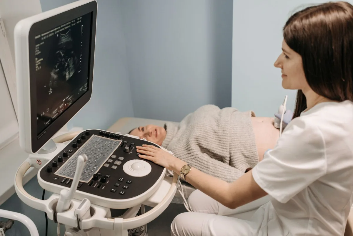 Jordemoder udfører en rolig ultralydsscanning af en gravid kvinde — tryg og smertefri undersøgelse